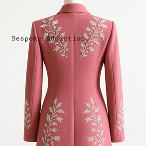 May include: A dusty rose blazer with intricate silver leaf embroidery on the back and sleeves. The text "Bespoke Addiction" is visible on the back of the blazer. The blazer is displayed on a mannequin.