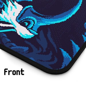 Op de afbeelding: Een muismat met een gepixelde blauwe en zwarte print met een gepixelde blauwe en witte print in de linkerbovenhoek. De muismat heeft een zwarte gestikte rand.