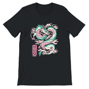 May include: Black t-shirt featuring a detailed illustration of a dragon in shades of teal, pink, and white. The dragon is in a curved pose with a Japanese text block and cherry blossom graphic. The shirt is made of a soft material.