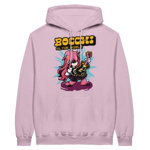 May include: A light pink hooded sweatshirt featuring a pixel art graphic of a character with long pink hair playing a black electric guitar. Above the character, the yellow pixelated text reads BOCCHI VS. THE WORLD, set against a blue burst.