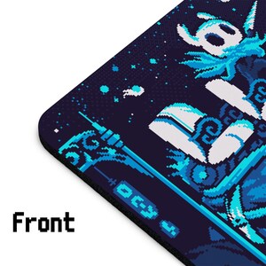 Op de afbeelding: Een blauwe en witte pixel art muismat met een personage uit het videospel Hollow Knight. Het personage houdt een naald vast en is omringd door een blauwe en witte achtergrond.