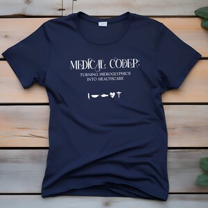 Puede incluir: Una camiseta azul marino con texto blanco que dice "MEDICAL CODER: TURNING HIEROGLYPHICS INTO HEALTHCARE" e incluye cinco pequeños iconos blancos.