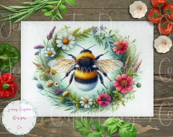 Op de afbeelding: Een aquarel schilderij van een hommel omringd door een krans van kleurrijke bloemen. De hommel is geel en zwart met pluche haar. De bloemen zijn roze, wit en paars.
