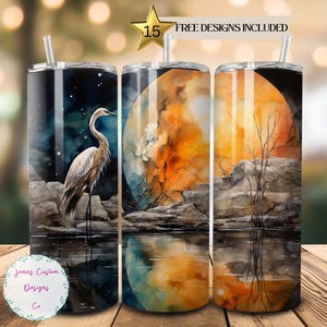 May include: Three stainless steel tumblers with different designs. The first tumbler features a white heron standing in a body of water with a moon and stars in the background. The second tumbler features a watercolor painting of a moon reflecting in a body of water. The third tumbler features a watercolor painting of a tree and rocks reflecting in a body of water.