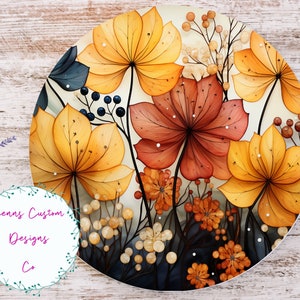 May include: A round, cream-coloured background with a watercolour painting of yellow, orange, and red flowers. The flowers are surrounded by small, white, and brown dots.