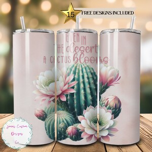 May include: A pink and white stainless steel tumbler with a cactus and flowers design. The tumbler has the text "Even in the desert a cactus blooms".
