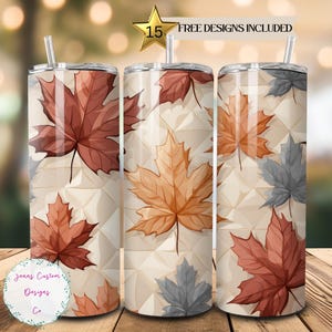 May include: Three stainless steel tumblers with a fall-themed design. The tumblers feature a white background with a geometric pattern and colorful maple leaves. The text "FREE DESIGNS INCLUDED" is visible at the top of the image.