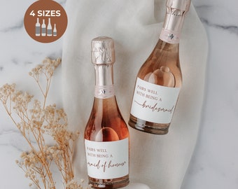 May include: Two small bottles of pink champagne with labels that say "Pairs well with being a bridesmaid" and "Pairs well with being a maid of honor".