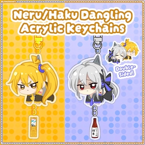 May include: Two acrylic keychains featuring chibi characters Neru and Haku. The Neru keychain has a yellow color scheme with a mobile phone charm, while the Haku keychain is blue-toned with a bottle charm. Both are double-sided with metal clasps.