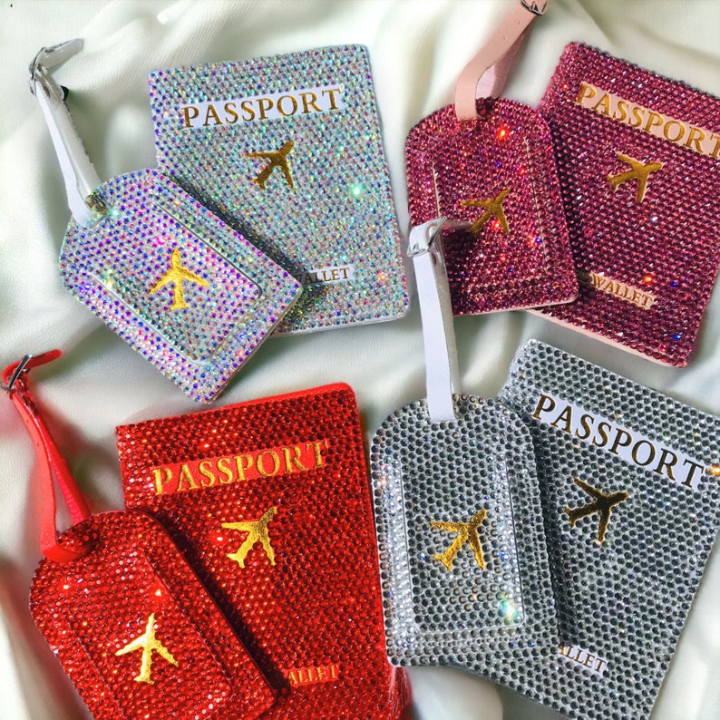 May include: Set of four passport holders and luggage tags with a rhinestone design. Each passport holder and luggage tag features a gold airplane graphic and the word "PASSPORT". The passport holders are red, pink, silver, and iridescent. The luggage tags are red, pink, silver, and iridescent.