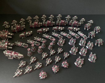 Pode incluir: Uma coleção de naves espaciais e veículos em miniatura pintados em prata e bordô. Os modelos estão dispostos em uma superfície preta.