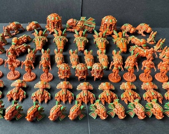 May include: A collection of 48 miniature figures painted in orange and green. The figures are of various shapes and sizes, and some have wings. The figures are arranged in rows on a black surface.