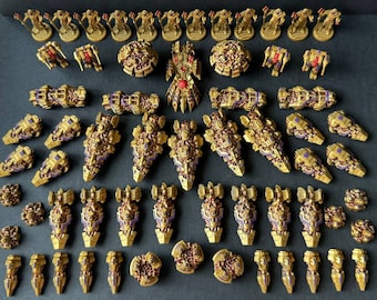 Pode incluir: Uma coleção de naves espaciais em miniatura douradas e roxas com detalhes intrincados. As naves espaciais estão dispostas em filas e colunas, com uma nave espacial maior e mais complexa no centro.