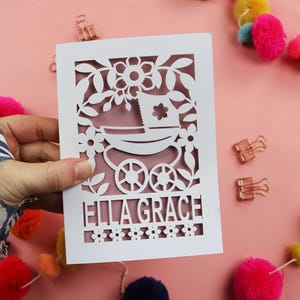 A personalised new baby card SVG for laser cutting with a vintage pram and floral border and baby's name