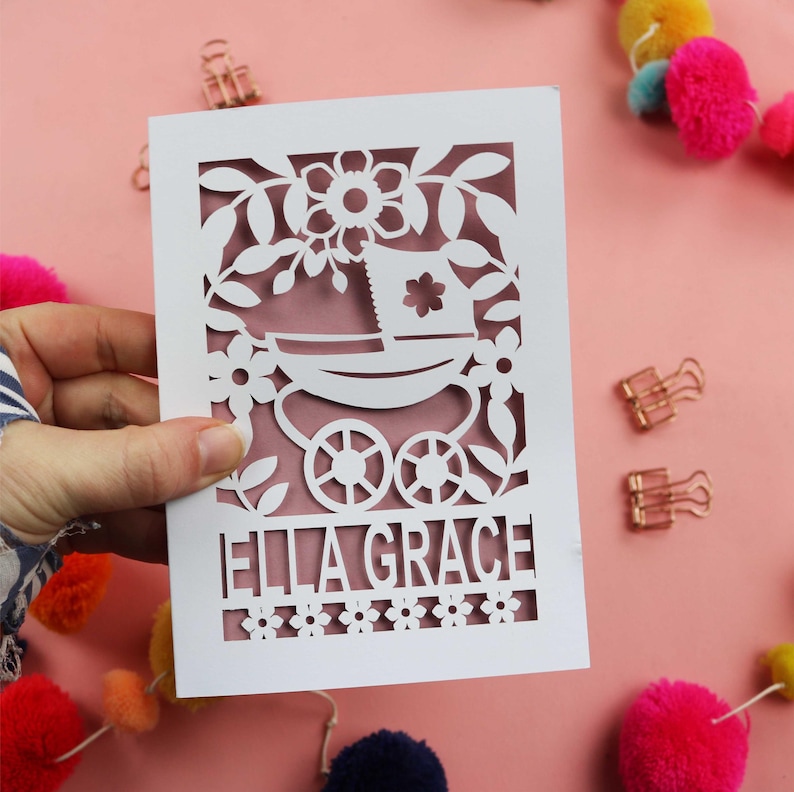 A personalised new baby card SVG for laser cutting with a vintage pram and floral border and baby's name