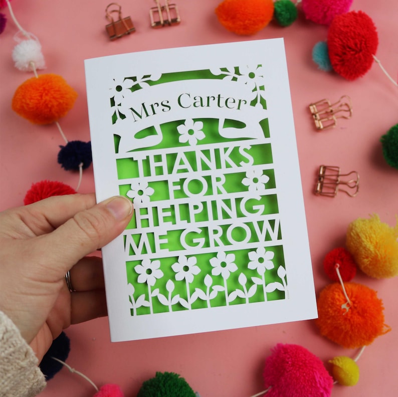 May include: White card with a green cutout design. The card says "Mrs. Carter" and "Thanks for helping me grow".