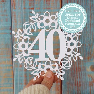 May include: White paper cut-out of the number 40 surrounded by a floral wreath. The wreath is made of leaves and flowers. The image is on a blue wooden background. SVG, PNG, JPEG, PDF Digital Download Commercial Use.