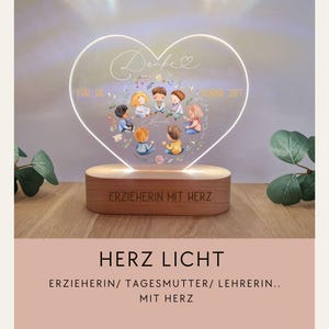 Può includere: Luce notturna a LED a forma di cuore con base in legno. Il cuore in acrilico trasparente presenta un design floreale e un gruppo di bambini. La base è incisa con testo. Progettato per educatori.