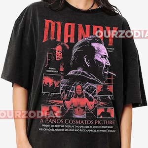 May include: Black t-shirt with a movie poster design for "Mandy." The design features the film's title in red, images of actors, and the text "A Panos Cosmatos Picture." The shirt has a vintage, worn appearance.