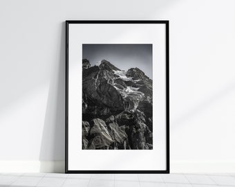 May include: A black and white photograph of a mountain range with a glacier. The mountain is rocky and the glacier is white. The photo is framed in a black frame.