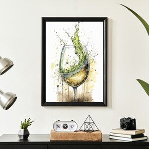 May include: A watercolour painting of a glass of white wine with a splash of green liquid coming out of the glass. The glass is on a brown background with white splatters.