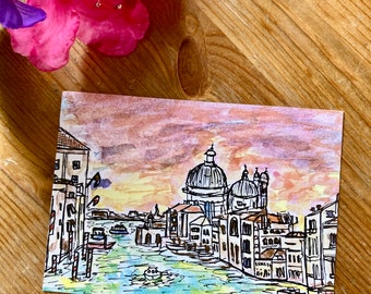 May include: Watercolor painting of a canal in Venice, Italy. The painting features a colorful sunset sky, a canal with boats, and buildings with domes.