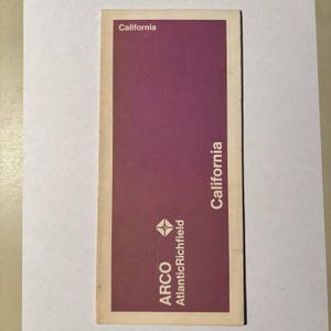 May include: A rectangular paper map of California featuring a solid purple background with white text. The text reads California at the top left and vertically on the right side. The ARCO AtlanticRichfield logo is printed in white at the bottom.