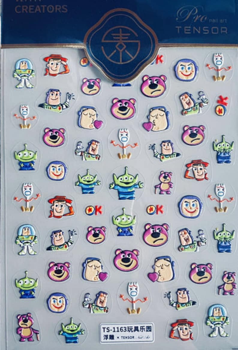 May include: A sheet of colorful nail art stickers featuring characters from the Toy Story franchise. The stickers include Woody, Buzz Lightyear, Jessie, Rex, and Mr. Potato Head. The stickers are arranged in a grid pattern on a white background. The text "TS-1163 玩具乐园 浮雕 TENSOR" is printed at the bottom of the sheet.