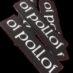 May include: A collection of black rectangular patches, each bearing the white text "oi polloi". The patches have a red border and are arranged on a black background.