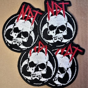 Op de afbeelding: Vijf zwarte en witte geborduurde patches met een schedel en gekruiste beenderen ontwerp. De schedel is wit met zwarte ogen en een rood "NOT" erboven geschreven.