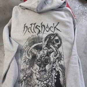 May include: A gray hooded sweatshirt with a black and white graphic print of a skull with a gas mask, a scorpion, and the text "hellshock".