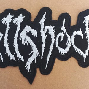 May include: Black and white embroidered patch with the word "HellShock" in a stylized font.