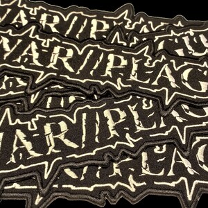 Può includere: Un mucchio di toppe in tessuto nero con testo ricamato bianco che recita "WARRIOR LEAGUE".