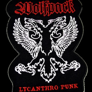 Op de afbeelding: Zwarte geborduurde patch met een witte tweelingwolf met vleugels en de tekst "Wolfpack Lycanthro Punk" in rood.