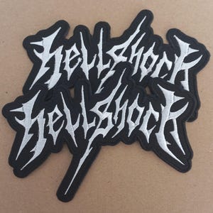 May include: Two black and white embroidered patches with the word "HellShock" in a stylized font.