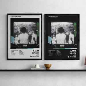 May include: Two framed posters featuring the album art for J. Cole's "4 Your Eyez Only." The posters have a black and white image of a person with other people in the background. The album title and tracklist are visible.