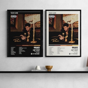 以下が含まれることがあります： 白い壁に、ドレイクのアルバム「Take Care」のフレーム入りポスターが2枚飾られています。ポスターにはドレイクの肖像画、ろうそく、アルバムの詳細が描かれています。ポスターは白黒で、金色のアクセントが施されています。アルバムタイトルとアーティスト名が表示されています。