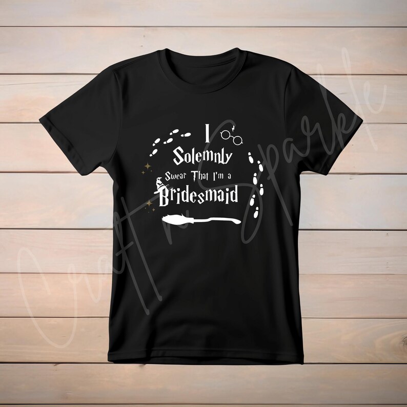 May include: Black t-shirt with white text that reads "I Solemnly Swear That I'm a Bridesmaid" with a graphic of a broom and footprints.