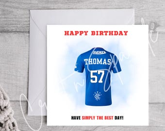 May include: Happy birthday card featuring a blue soccer jersey with the name "Thomas" and the number "57" on the back. The jersey has a white logo and the text "SEKO" on the top. The card has the text "Happy Birthday" and "Have simply the best day!"