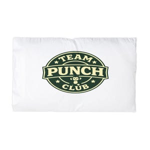 Könnte beinhalten: Weißes Kopfkissen mit einem grün-schwarzen "TEAM PUNCH CLUB" Logo. Das Logo zeigt eine Affenillustration und Sternakzente, wodurch ein verspieltes Design entsteht. Das Kissen ist rechteckig.