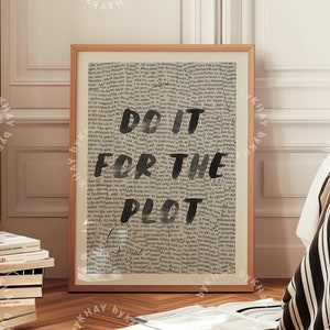 May include: A framed print with a black and white newspaper background and the text "DO IT FOR THE PLOT" in black.