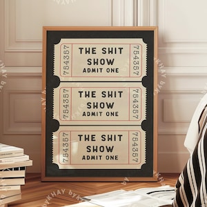 May include: A black framed print with three vintage-style tickets that read "The Shit Show, Admit One". The tickets are on a black background with white text and red accents.