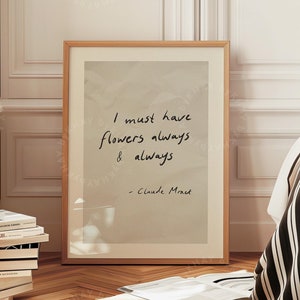 Może przedstawiać: Wydruk w ramie z beżowym tłem i cytatem w czarnym atramencie, który brzmi "Muszę mieć kwiaty zawsze i zawsze - Claude Monet". Wydruk wisi na białej ścianie w pokoju z drewnianymi podłogami.