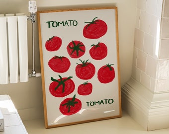 May include: A framed art print featuring a hand-drawn illustration of red tomatoes with green stems on a white background. The word "TOMATO" is written in green at the top and bottom. The artwork is displayed in a bright, sunlit room.
