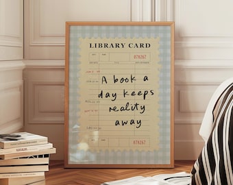 May include: A framed print featuring a vintage library card design with the quote "A book a day keeps reality away." The print has a light blue gingham border and a wooden frame. A stack of books sits on the floor.