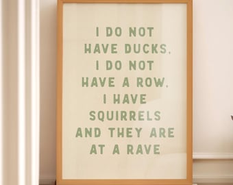 May include: A framed print with a white background and green text that reads "I do not have ducks. I do not have a row. I have squirrels and they are at a rave."