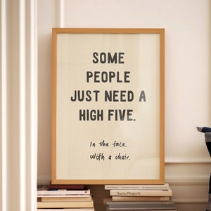 May include: A framed print with a white background and black text that reads "SOME PEOPLE JUST NEED A HIGH FIVE. In the face. With a chair."