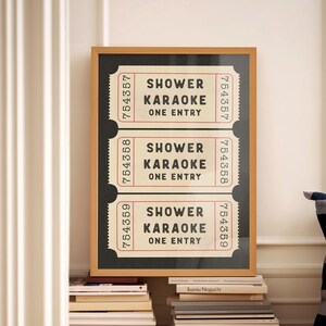 May include: A framed print with three vintage-style tickets that read "Shower Karaoke One Entry" in black text on a white background. The tickets are numbered 754357, 754358, and 754359.