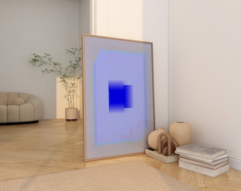 May include: A framed abstract art print with a blue and purple gradient design. The print is leaning against a white wall in a room with a light wood floor. There are a few decorative objects on the floor in front of the print.