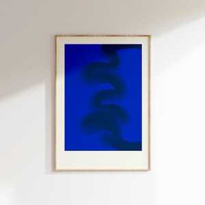 May include: A framed abstract art print with a dark blue, swirling design on a bright blue background.